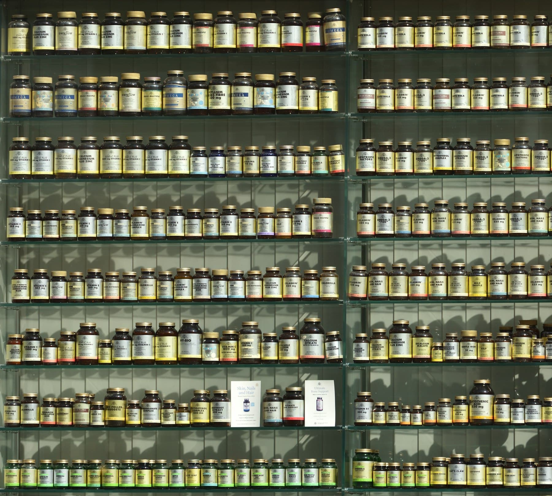 Boccette etichettate allineate sullo scaffale di una farmacia