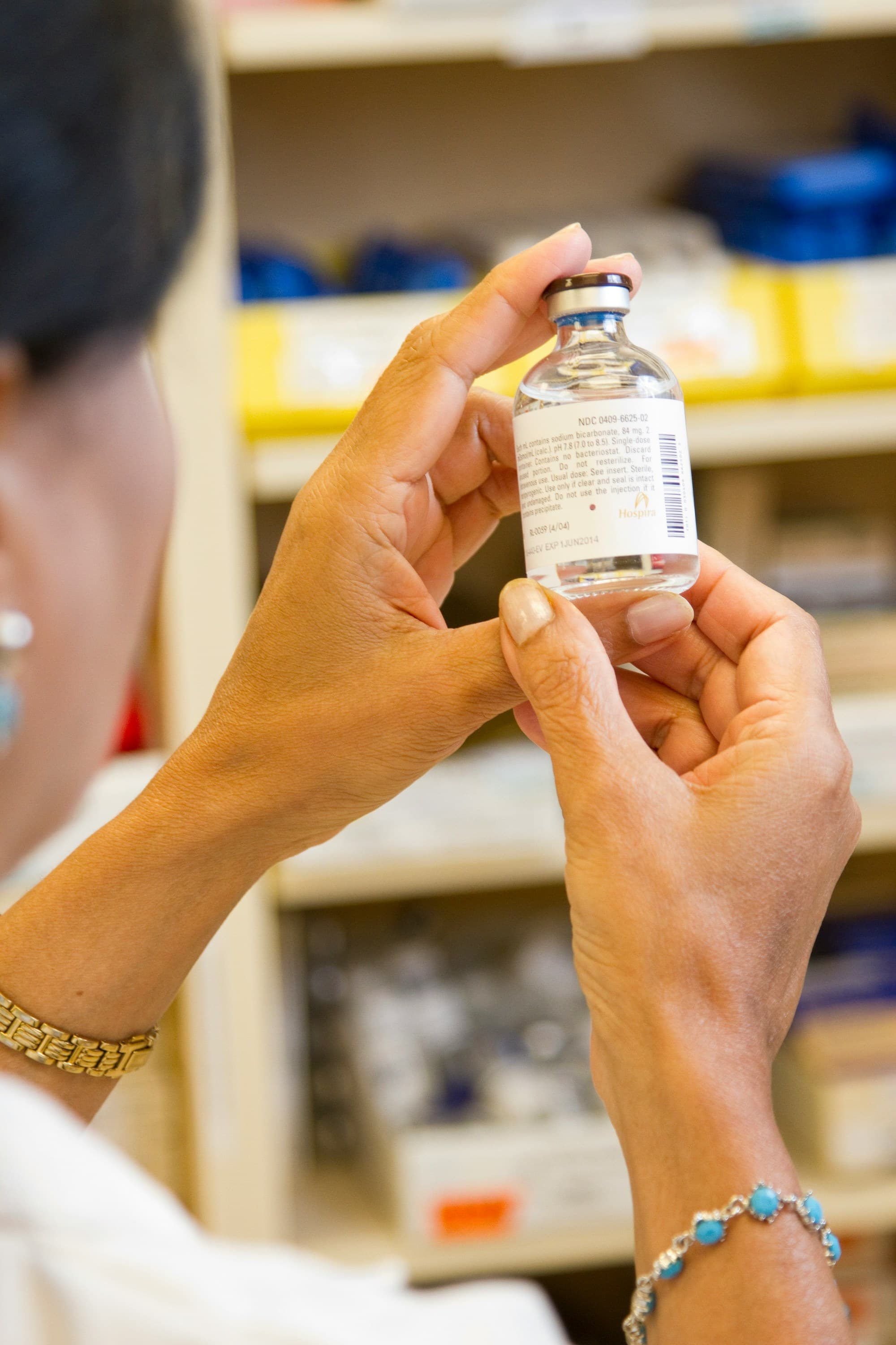 Farmacista controlla l'etichetta di un flacone nel retrobottega